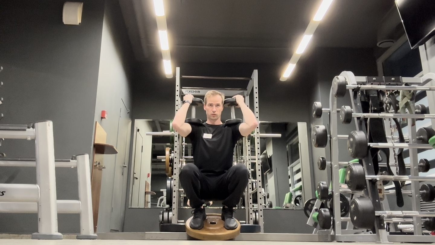 Приседания с гантелями на плечах