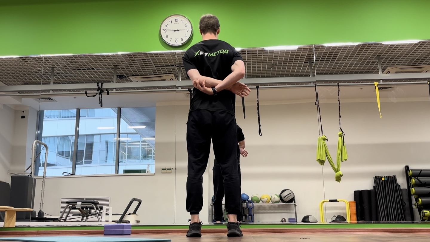 Растягивание отводящих мышц плеча стоя/лёжа на животе (рука за спиной)