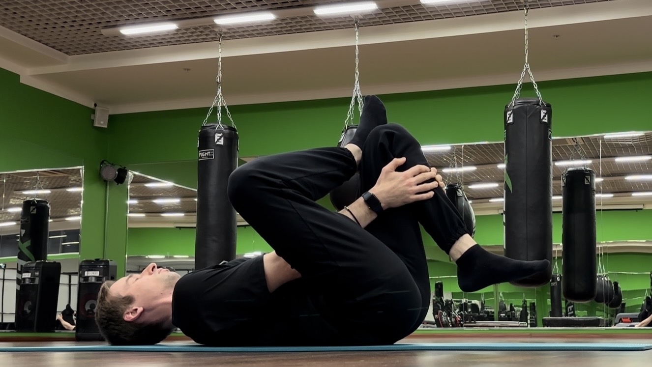 Растяжка ягодичных и грушевидной лёжа на полу обхватив бедро