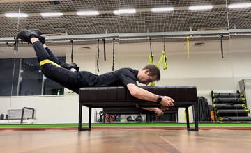 Обратная гиперэкстензия на скамье с мини-бэндом между ногами